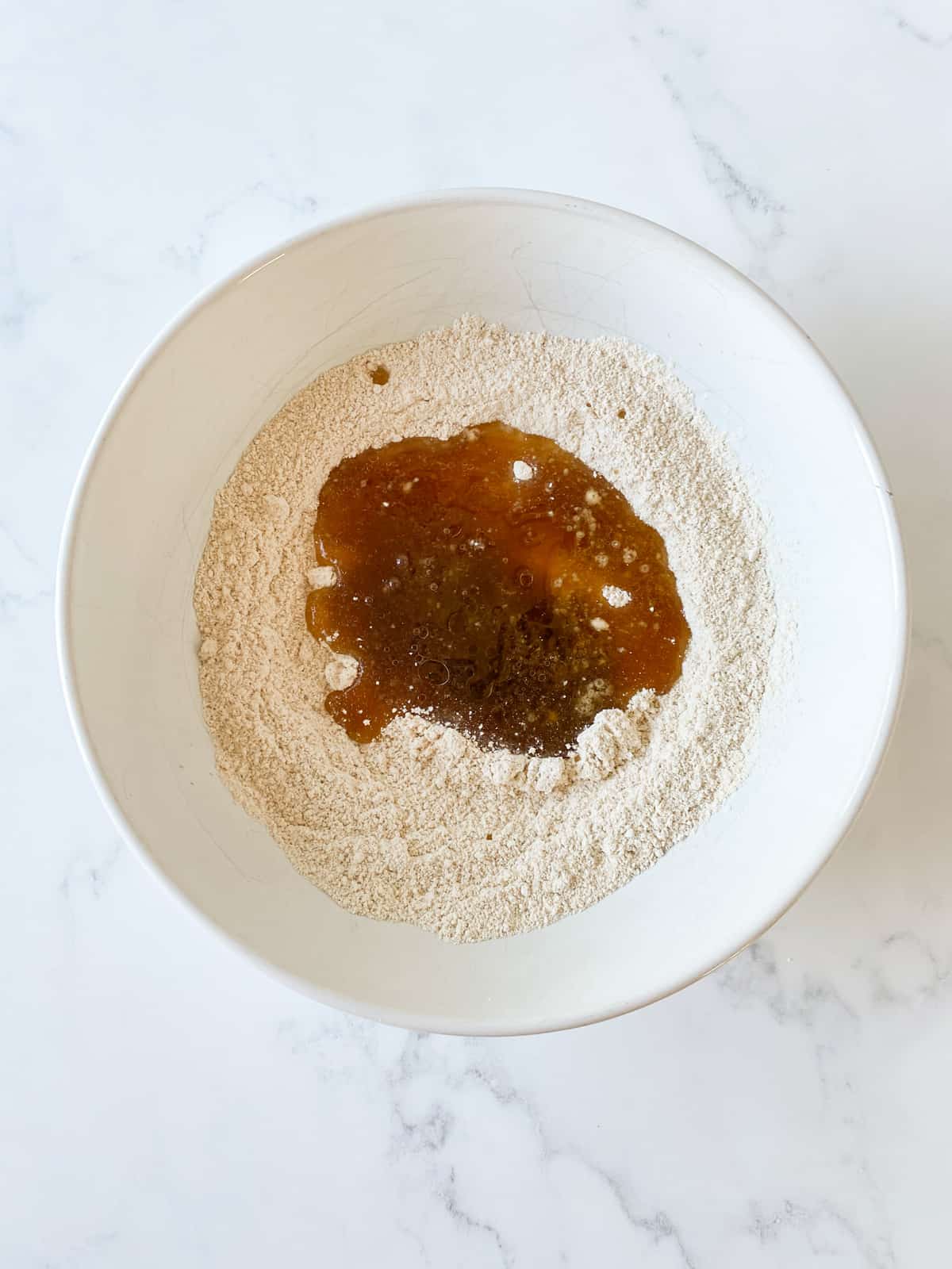 Wet and dry cookie ingredients, combined, in a bowl.