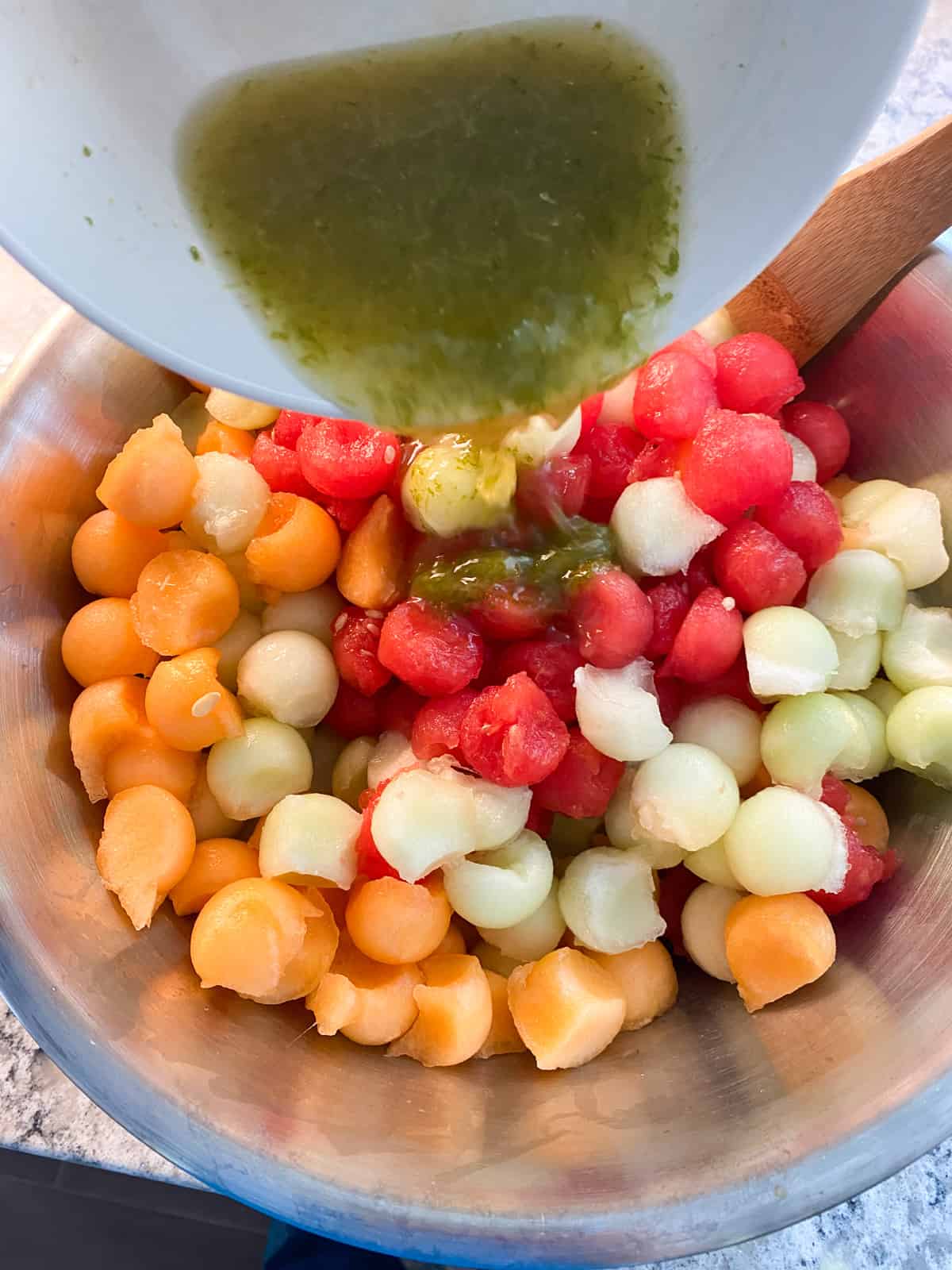 Dressing being poured over the melon.