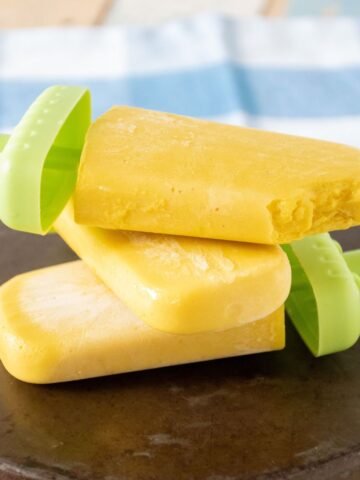 Pile of 3 popsicles lying on a dish.
