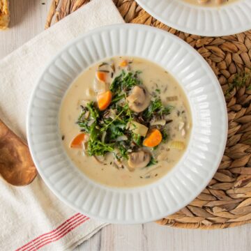 Overhead shot of creamy mushroom soup with kale in a bowl.