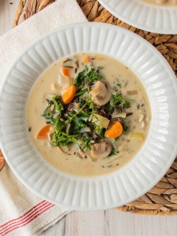 Overhead shot of creamy mushroom soup with kale in a bowl.