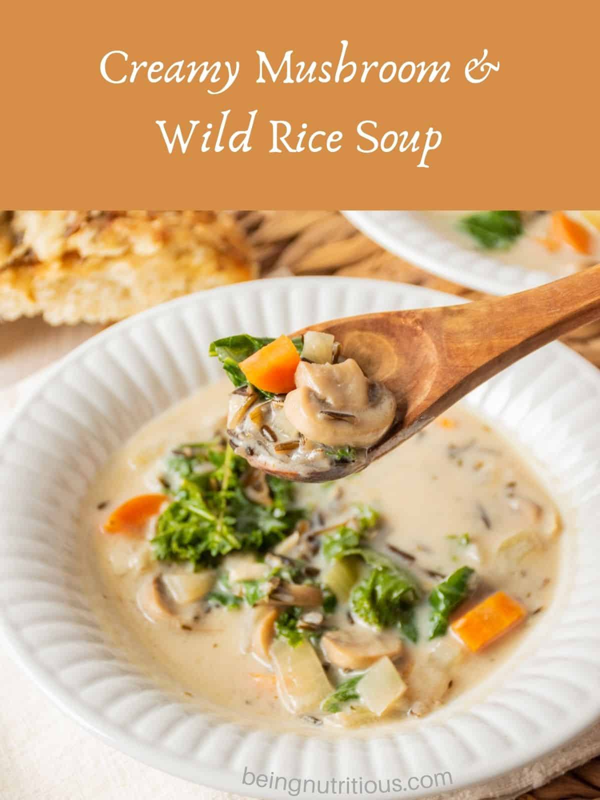 Soup in a bowl, with a wooden spoon being lifted out of the bowl with some soup on it. Text overlay: Creamy Mushroom and Wild Rice Soup.