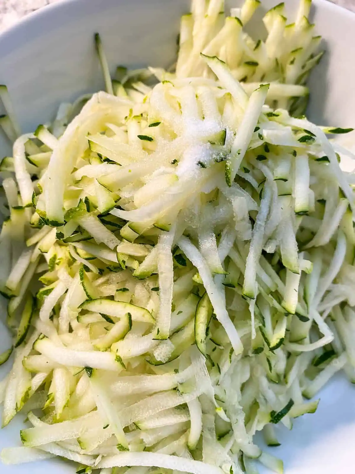 Salt added to the shredded zucchini.