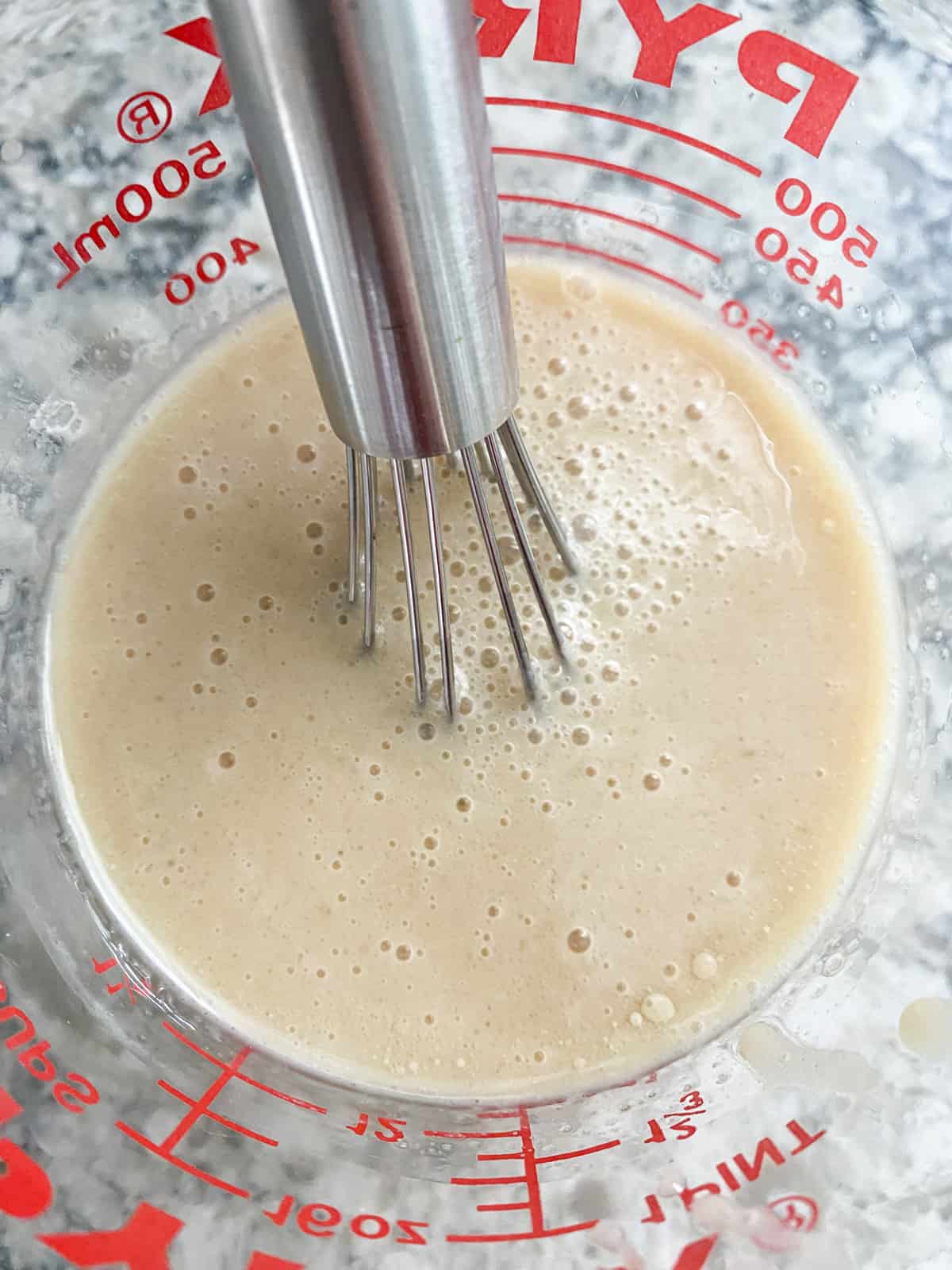 Wet ingredients for cookies mixed in a liquid measuring cup.