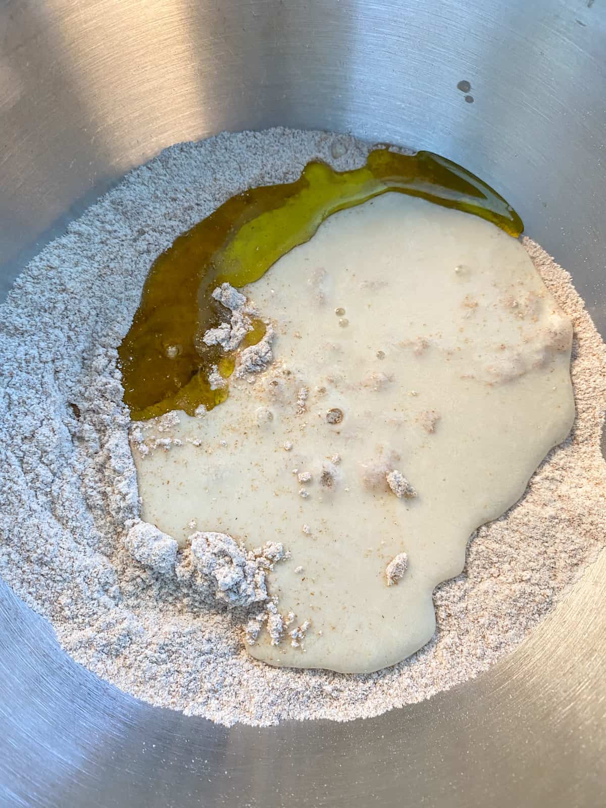 Wet ingredients poured into dry ingredients, in a mixing bowl.