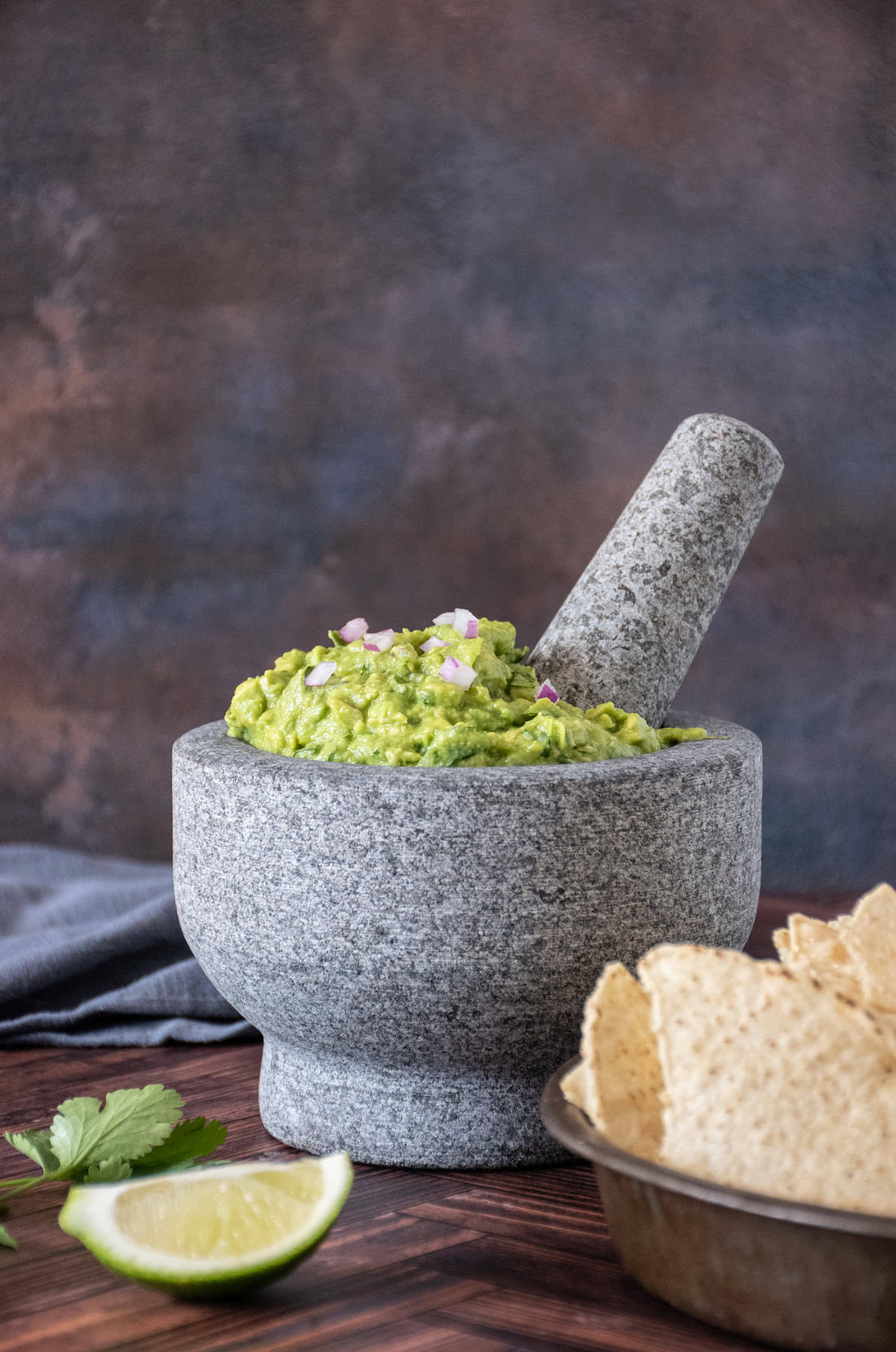 Large stone mortar and pestle filled with guacamole.