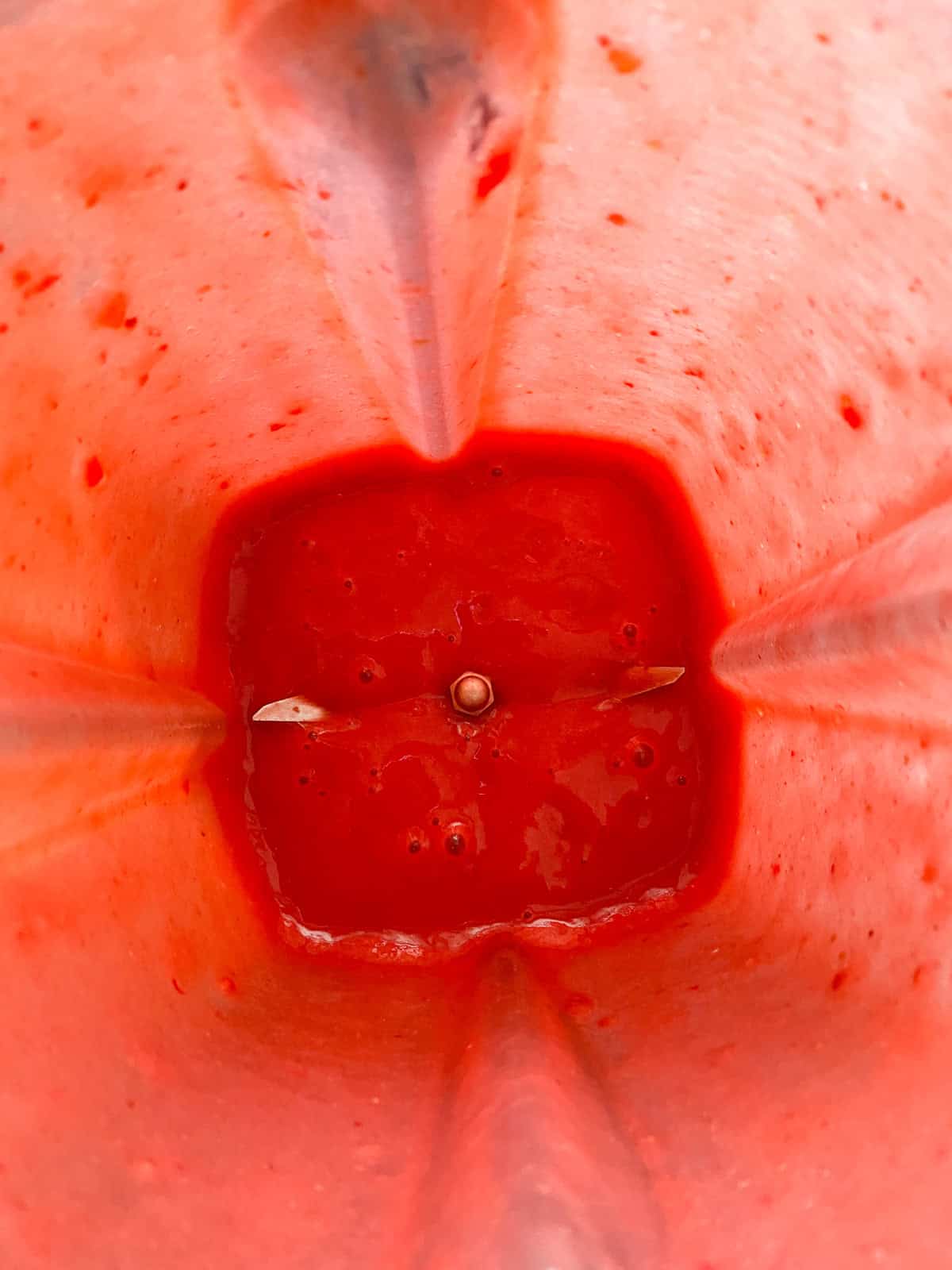 Blended strawberry sauce in a blender.