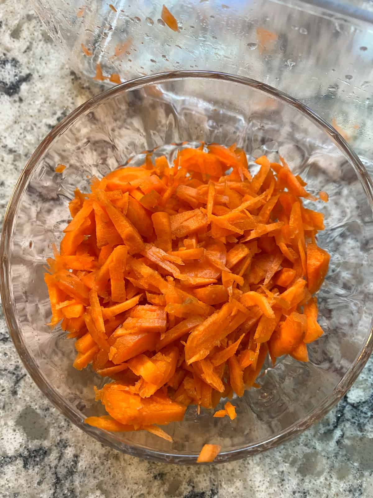 Shredded carrots in a small bowl.