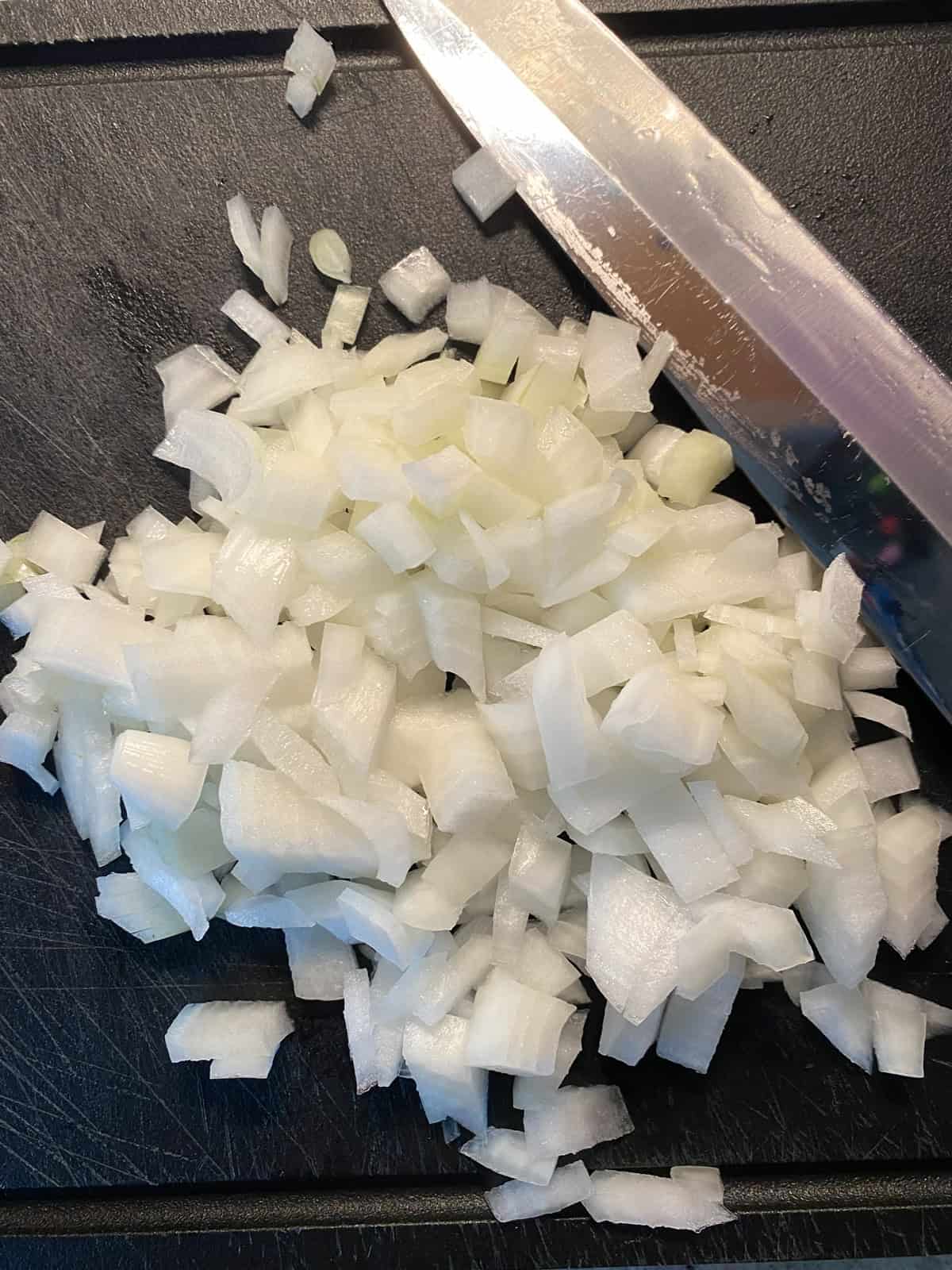 Chopped onions on a cutting board.