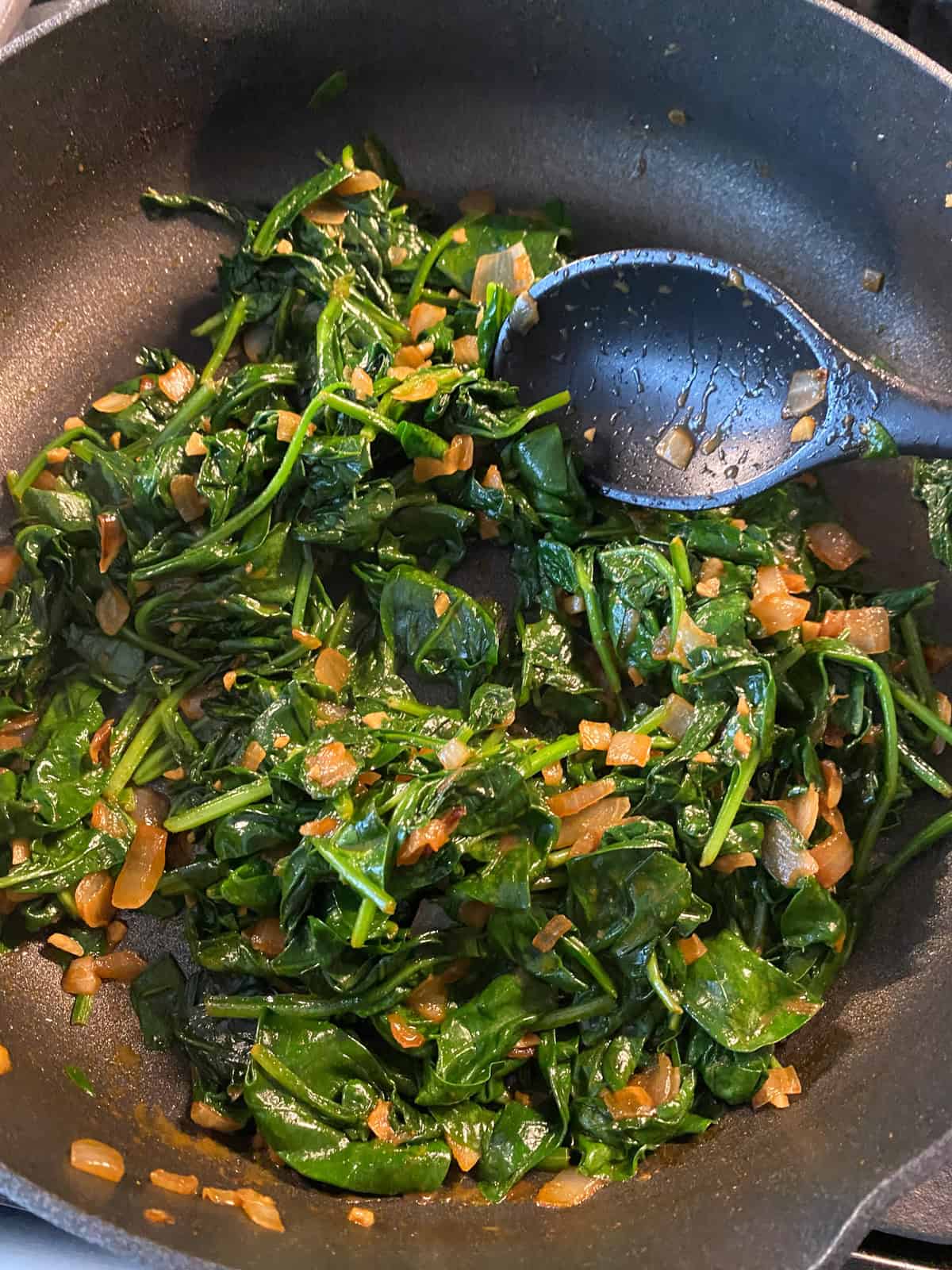 Completed sauteed spinach recipe, in a large pan.