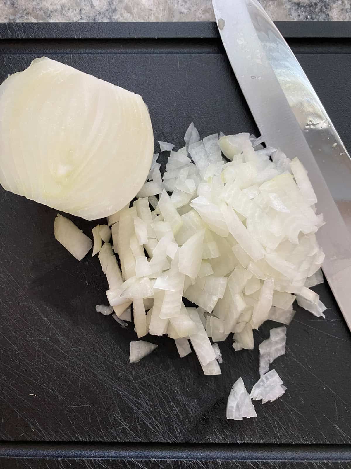 Diced onion on a cutting board.