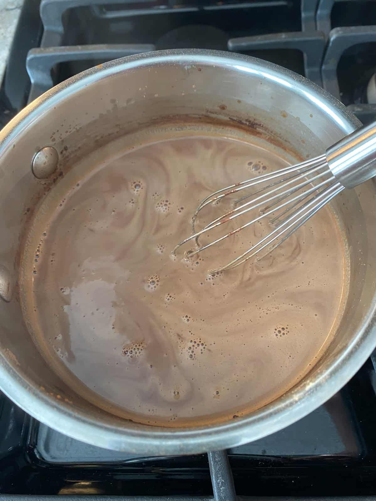 Hot cocoa, in a saucepan with a whisk.