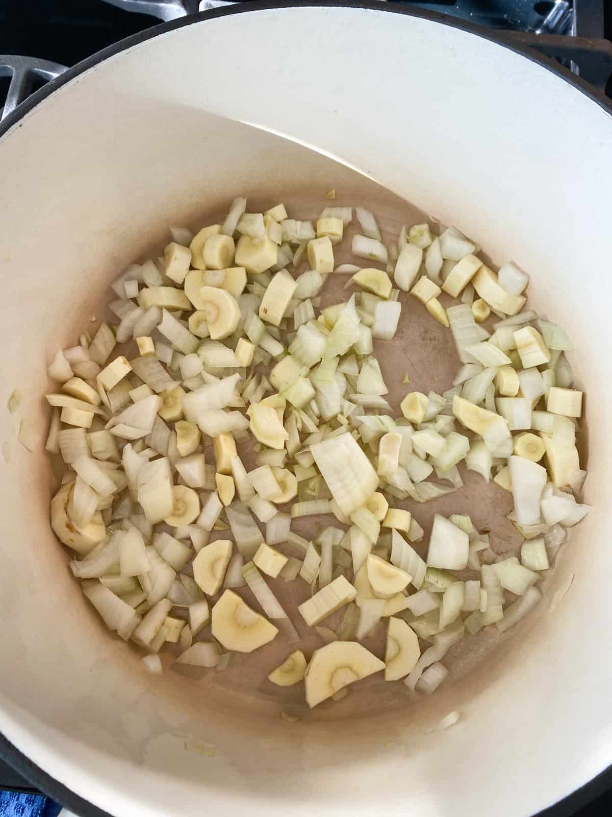 Chopped vegetables sauteing in a pot.