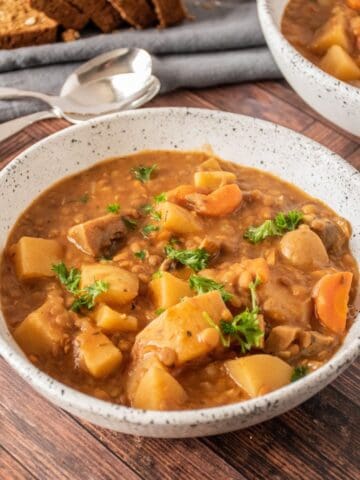 Bowl of lentil and mushroom stew, garnished with parsley.