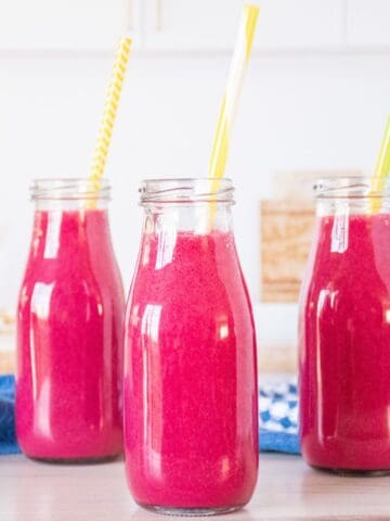Three small jars of smoothie, with straws.