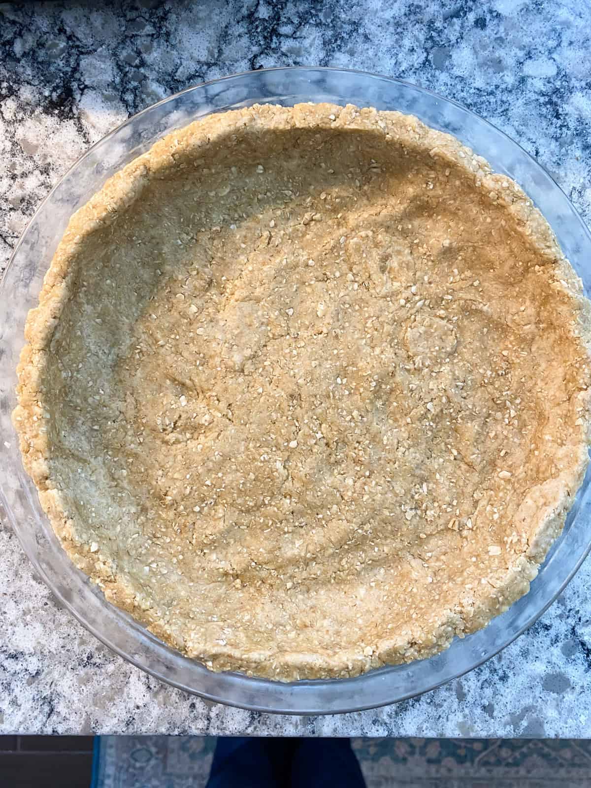 Dough pressed into a pie plate to form the crust.