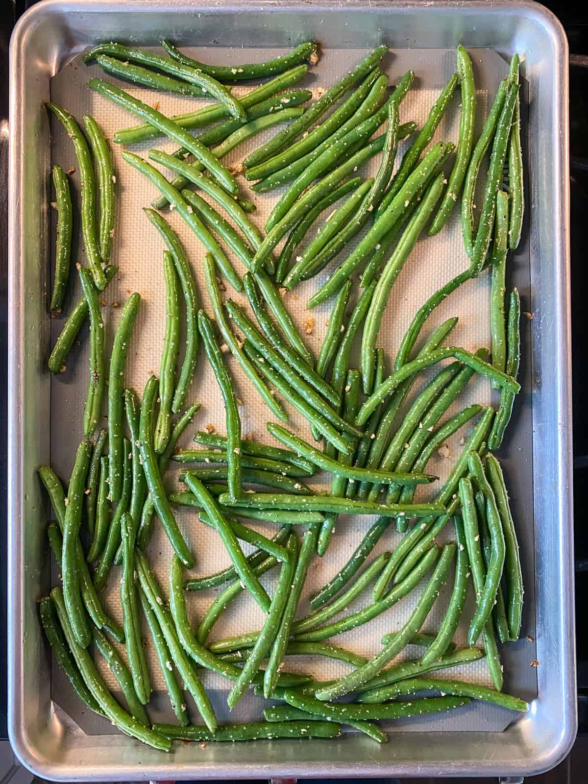 Finished roasted green beans on a baking sheet.