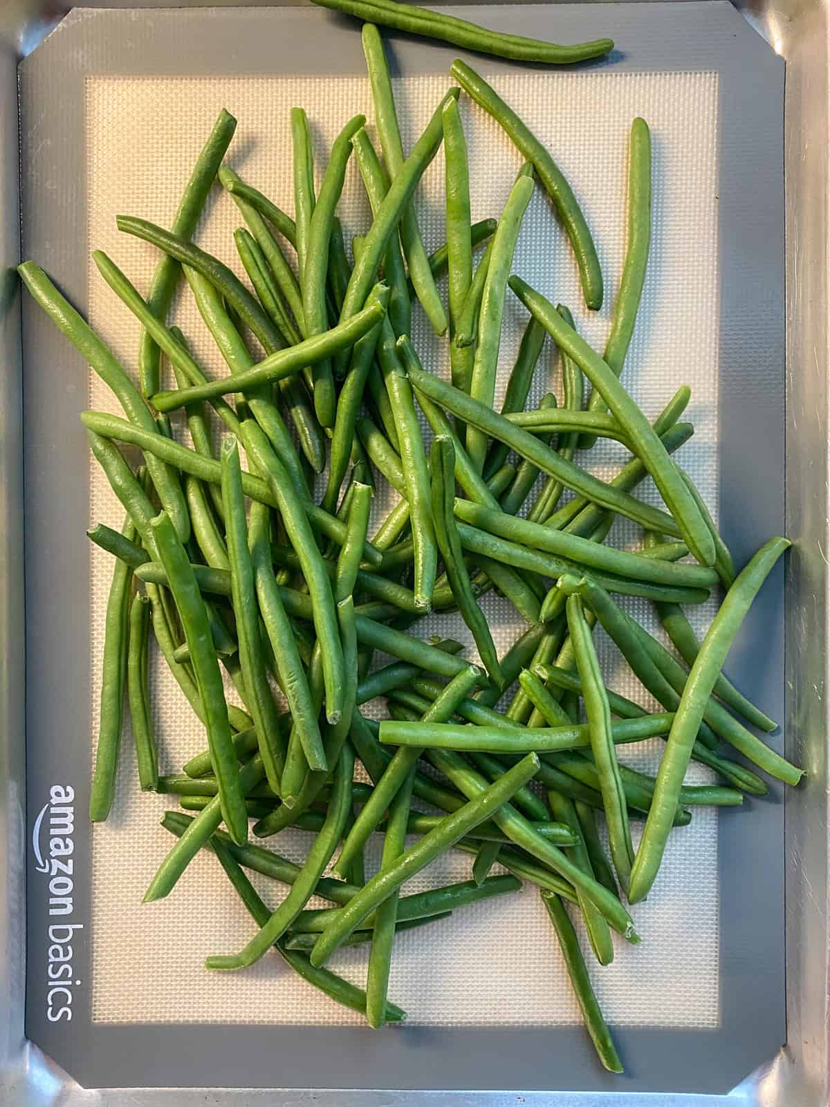 Fresh green beans on a baking sheet.