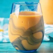 Close up glass of mango orange smoothie.