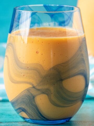 Close up glass of mango orange smoothie.