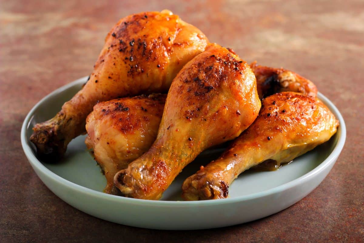 Plate of cooked chicken drumsticks.