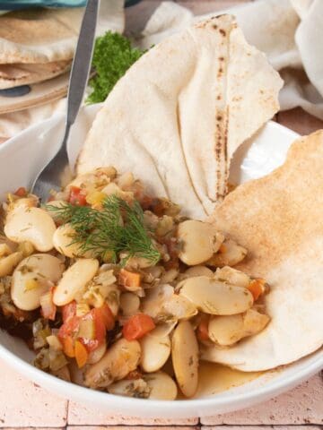 Greek lima beans in a bowl, with a pita.