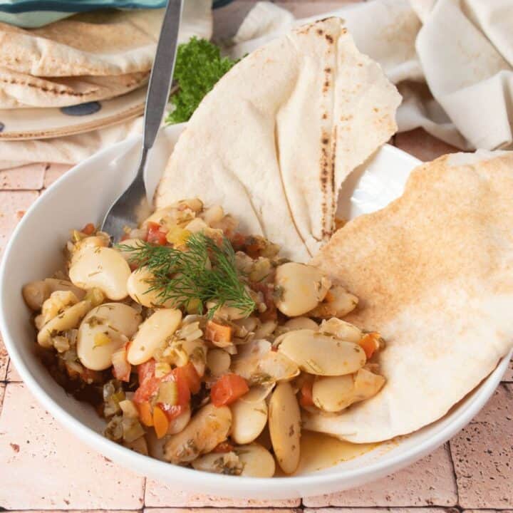 Greek lima beans in a bowl, with a pita.