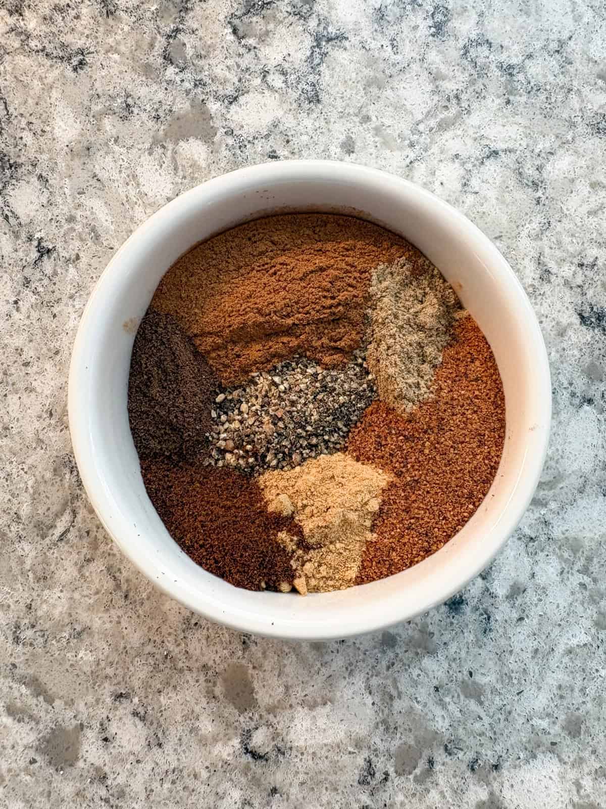 All the ingredients for chai spice in a bowl.