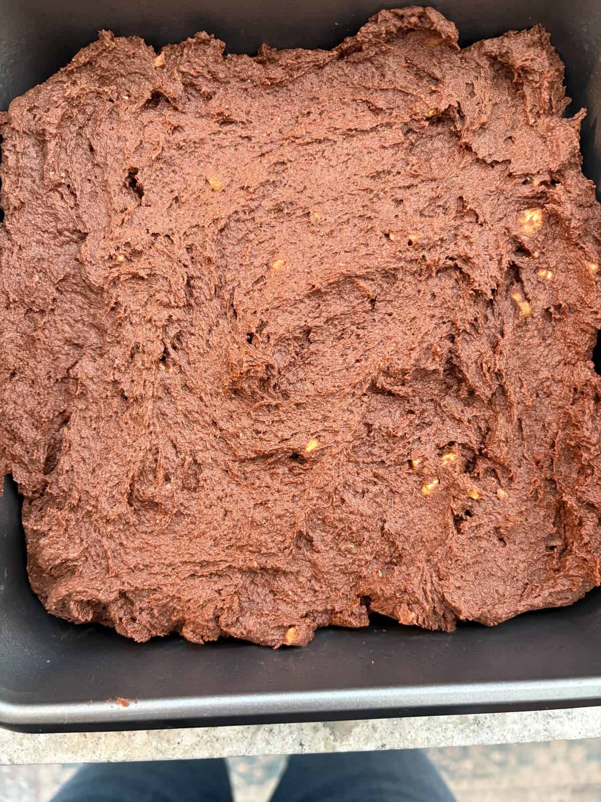 Brownie batter spread in a pan.