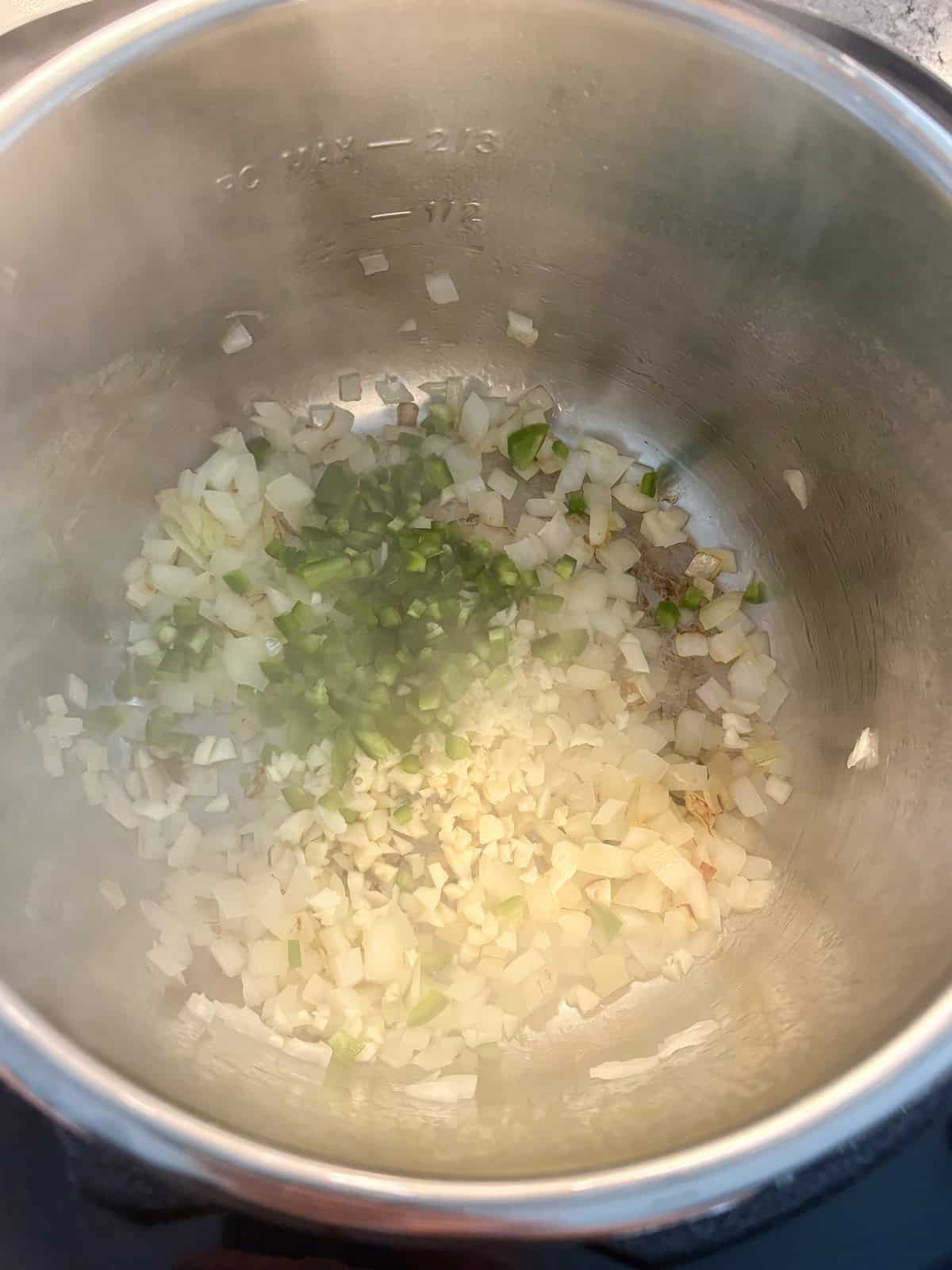 Minced garlic and jalapeño added to the pressure cooker to sauté.