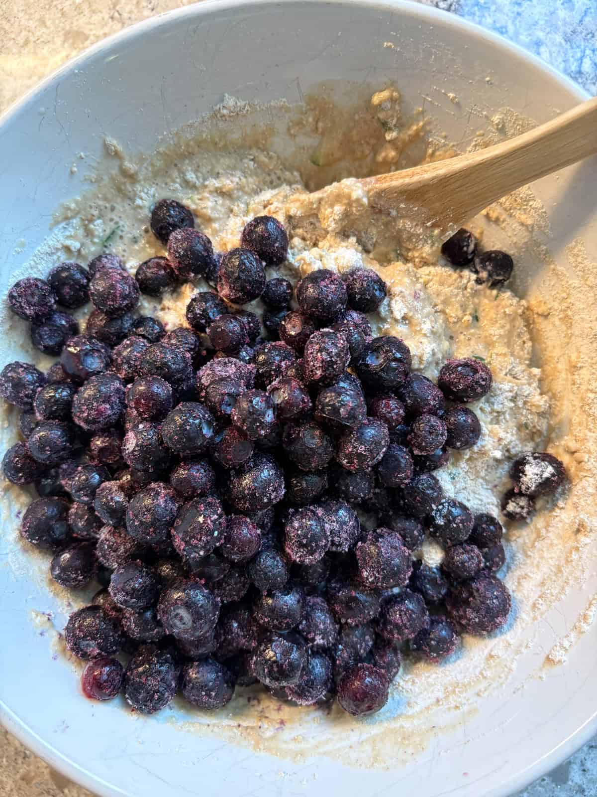 Blueberries poured into batter.