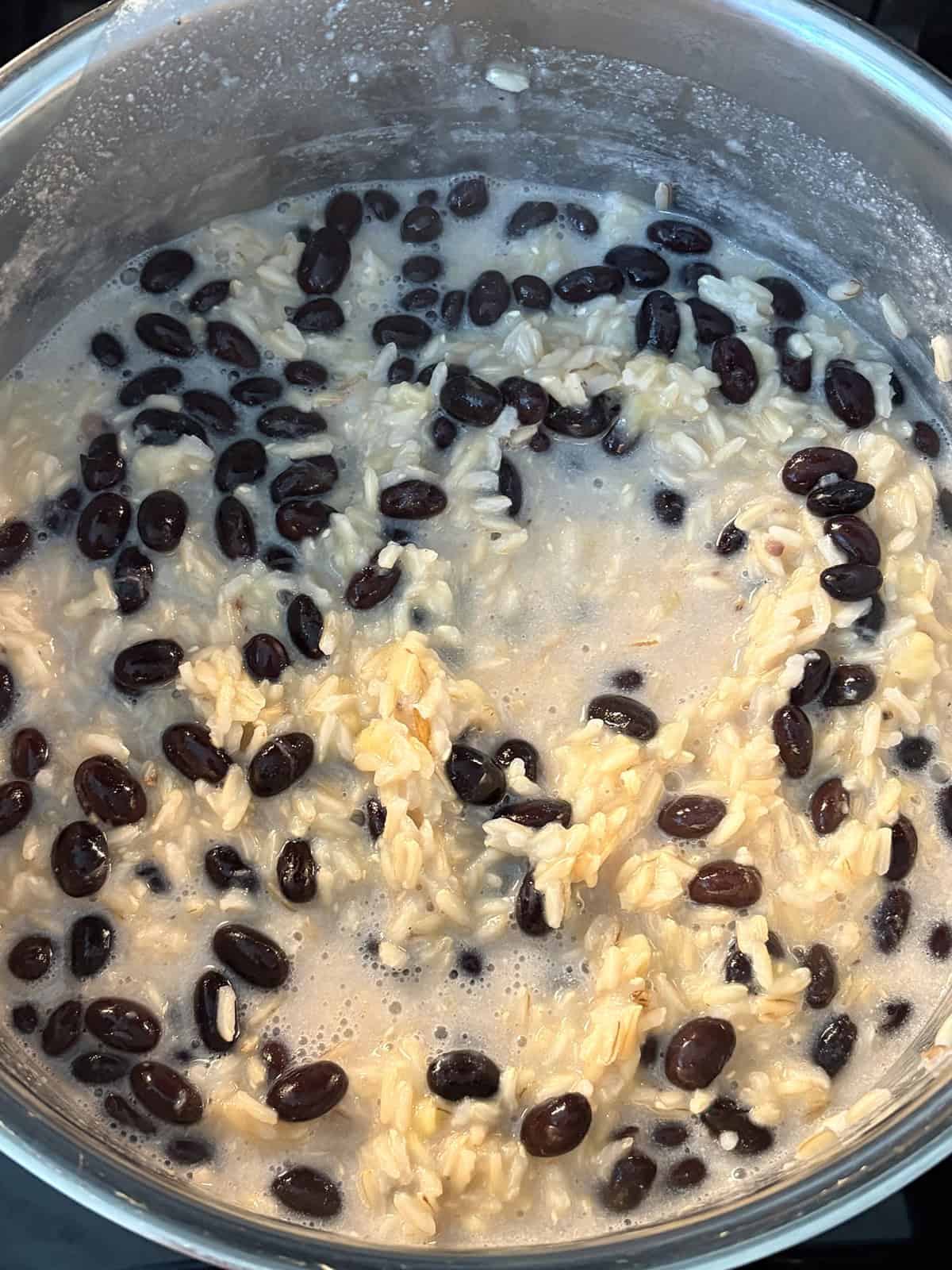 Almost cooked rice with beans and banana stirred in.