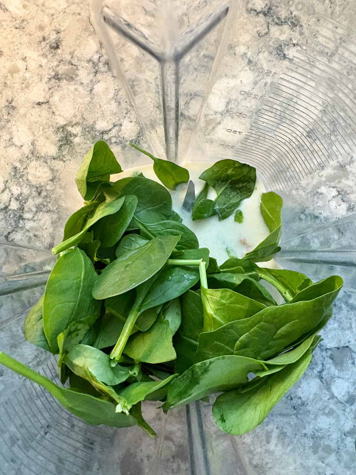 Cashews, soy milk, and spinach in a blender.