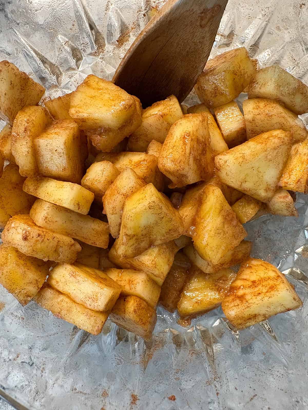 Pineapple pieces in a bowl mixed with lime juice and cinnamon.