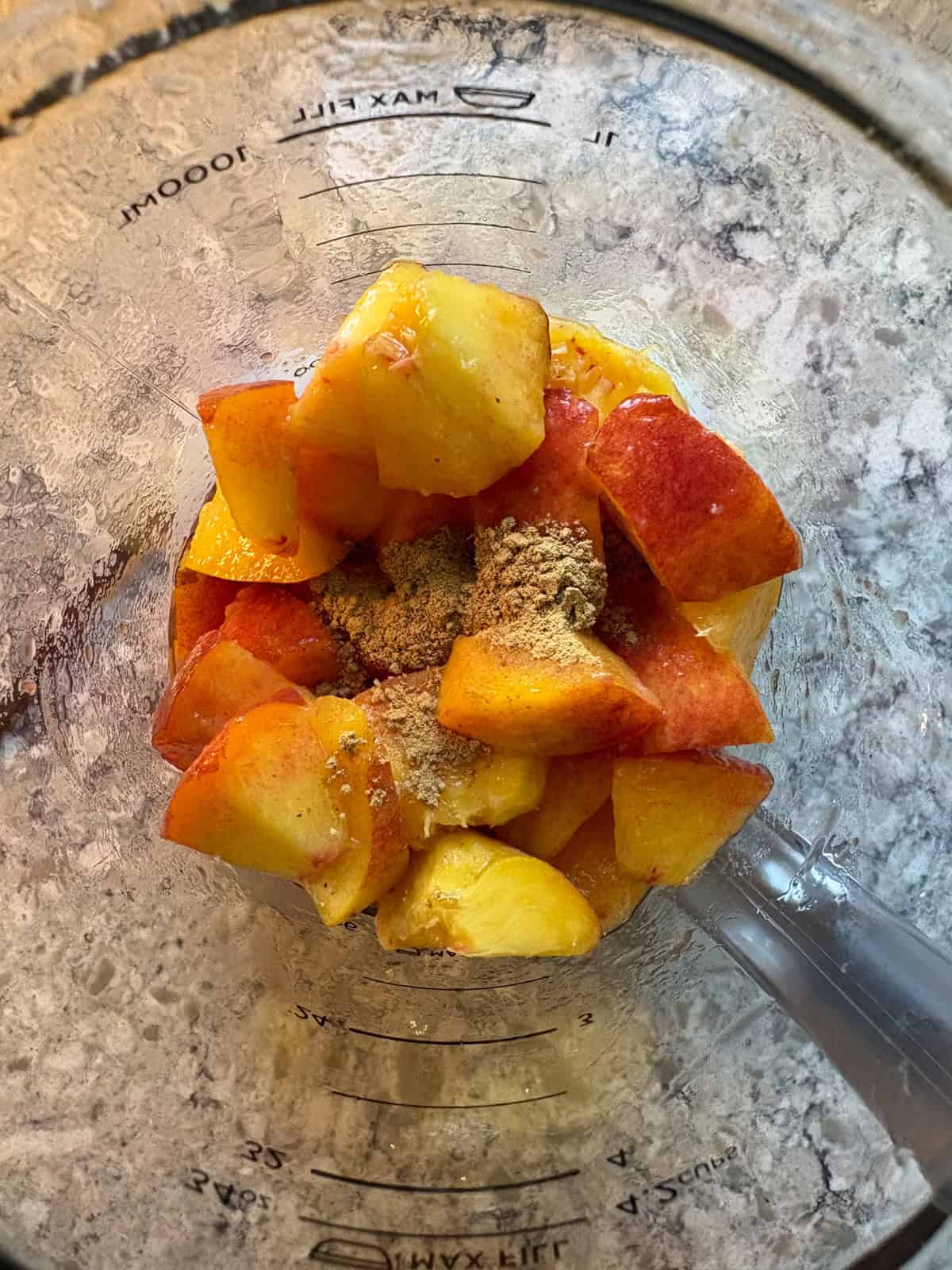 Chopped peaches and ginger in a blender.