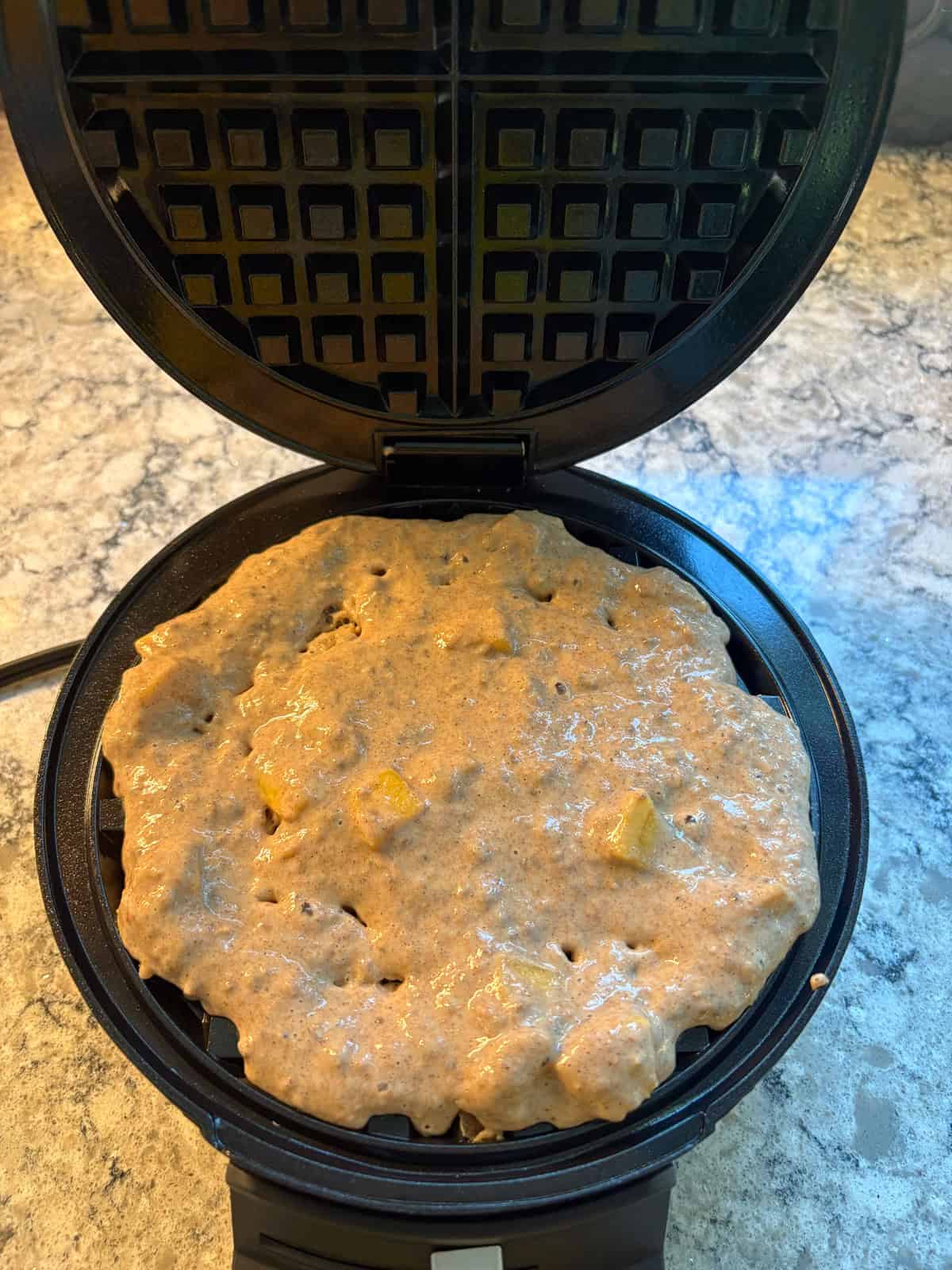 Waffle batter poured into waffle maker.