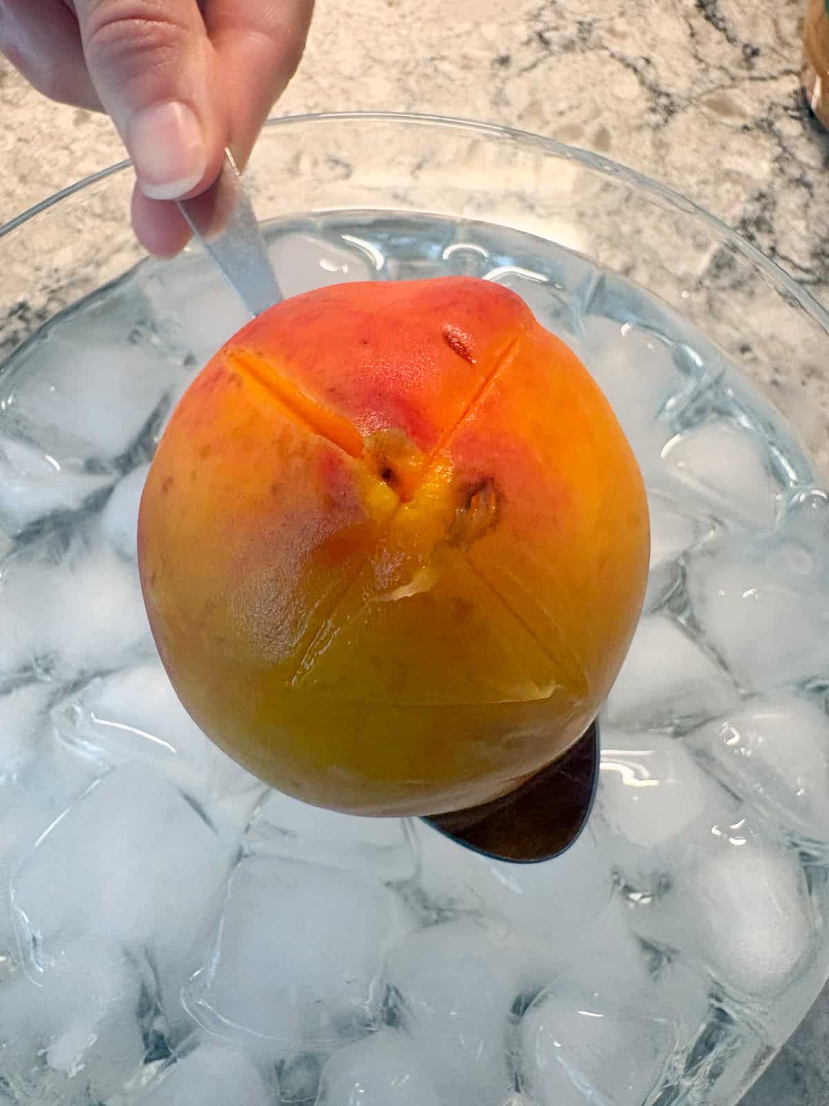 Blanched peach coming out of the ice bath.