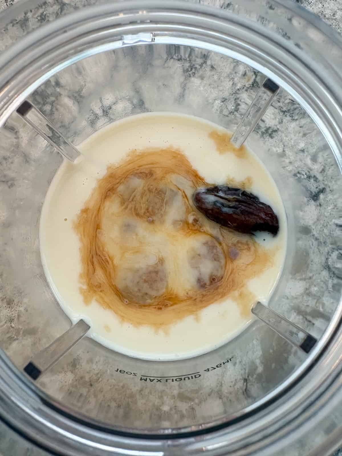 Milk, dates, and vanilla combined in a blender.