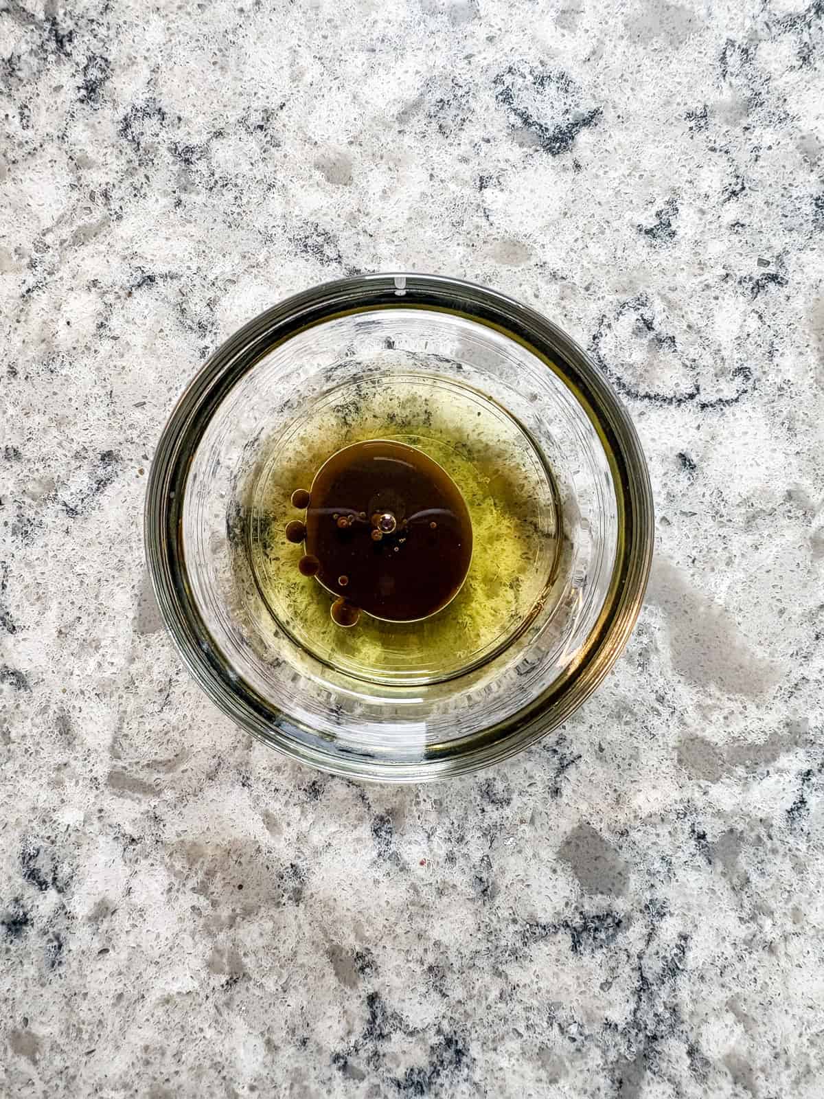 Oil and liquid smoke combined in a small bowl.