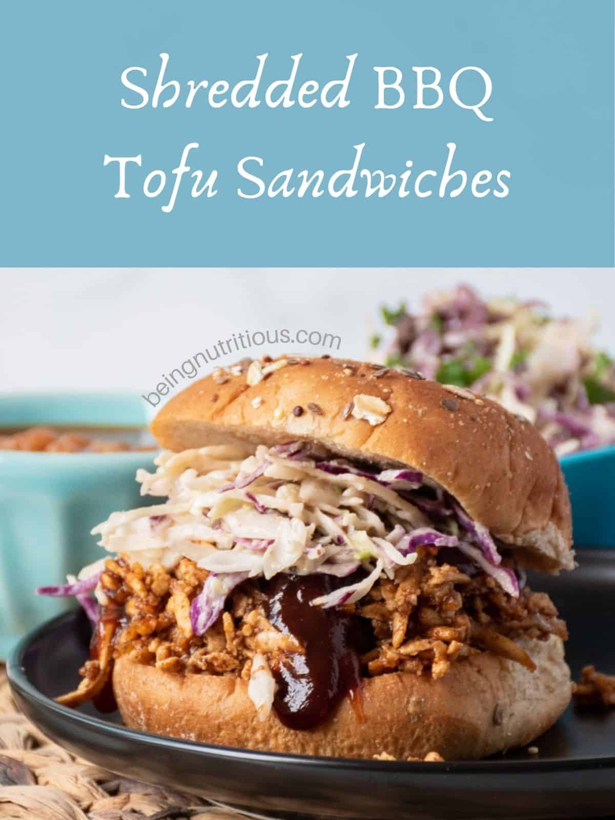 Close up of BBQ tofu sandwich with coleslaw, on a hamburger bun. Text overlay: Shredded BBQ Tofu Sandwiches.