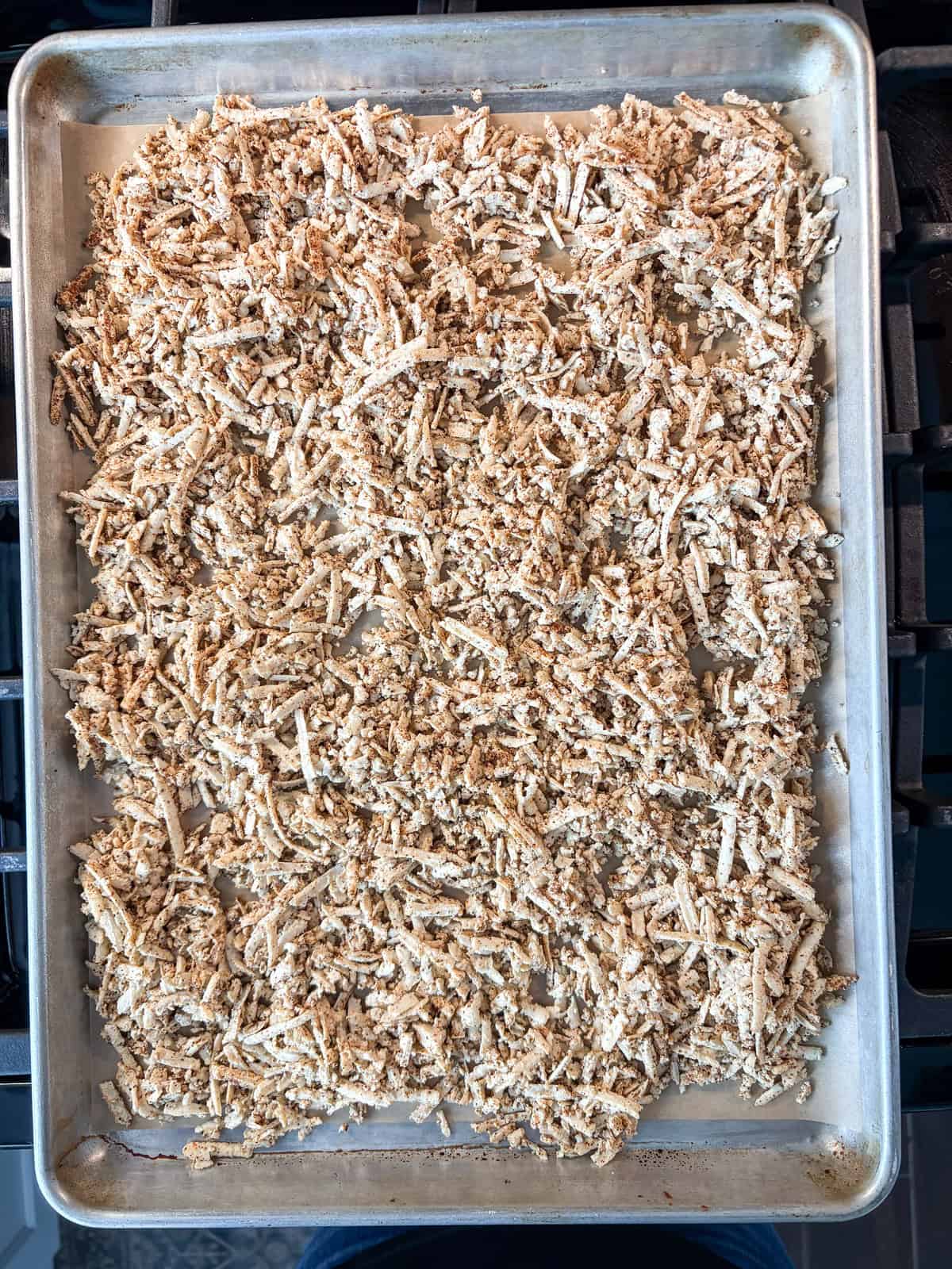 Seasoned, shredded tofu on a baking sheet, ready to go in the oven.