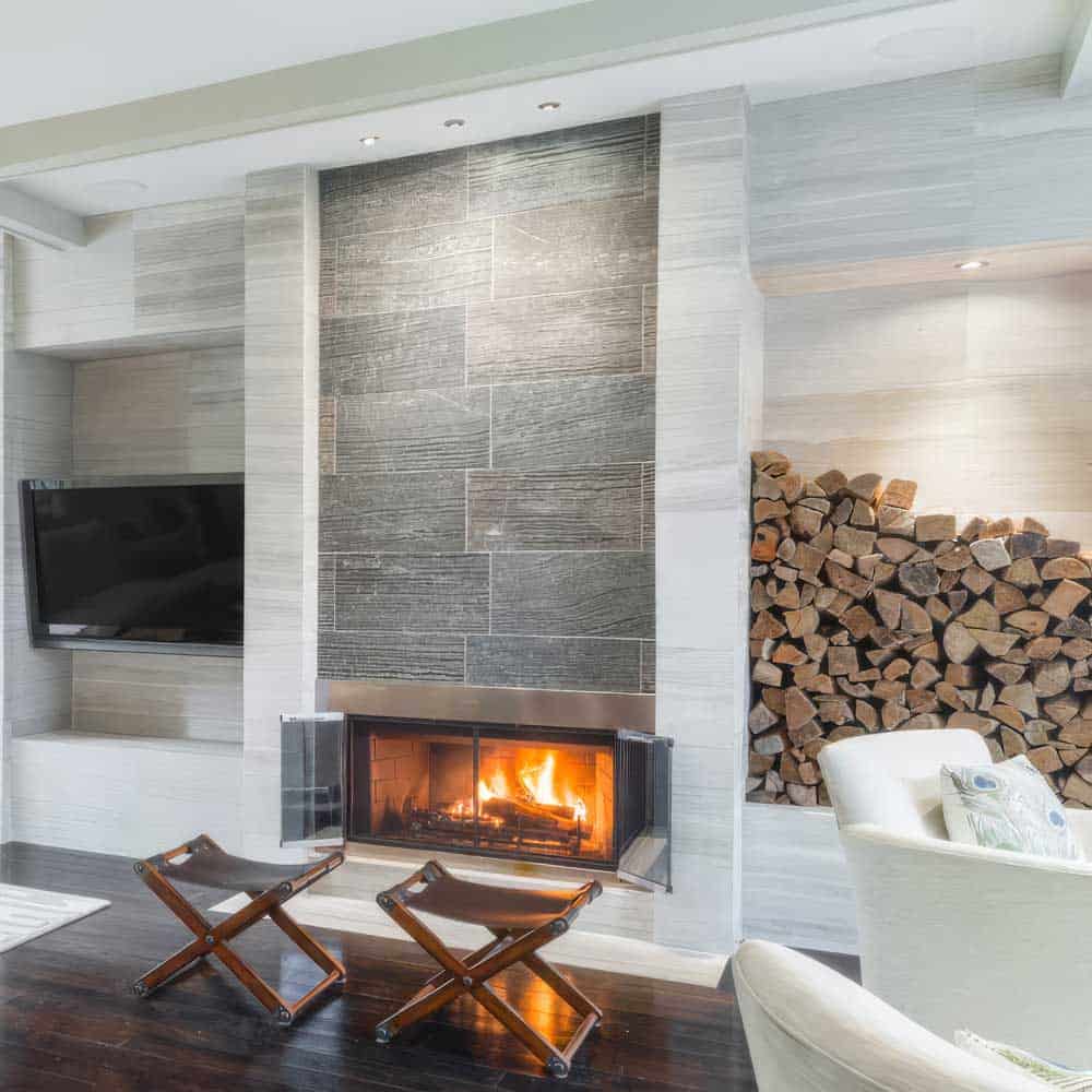 Modern living room with fireplace, wood storage, and contemporary decor.