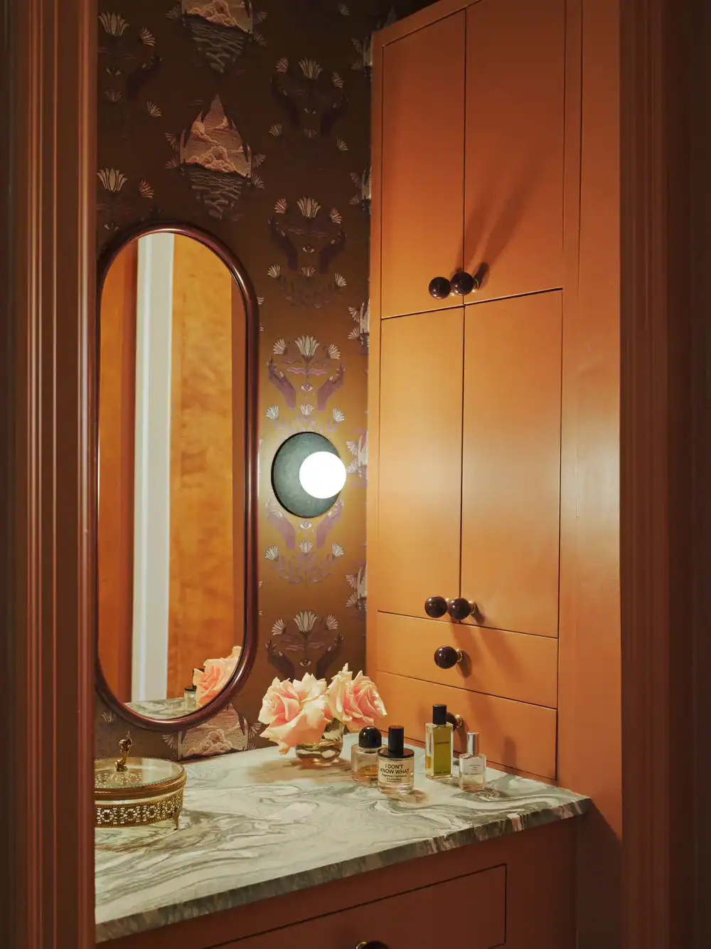 Elegant bathroom vanity with marble countertop and peach cabinetry.