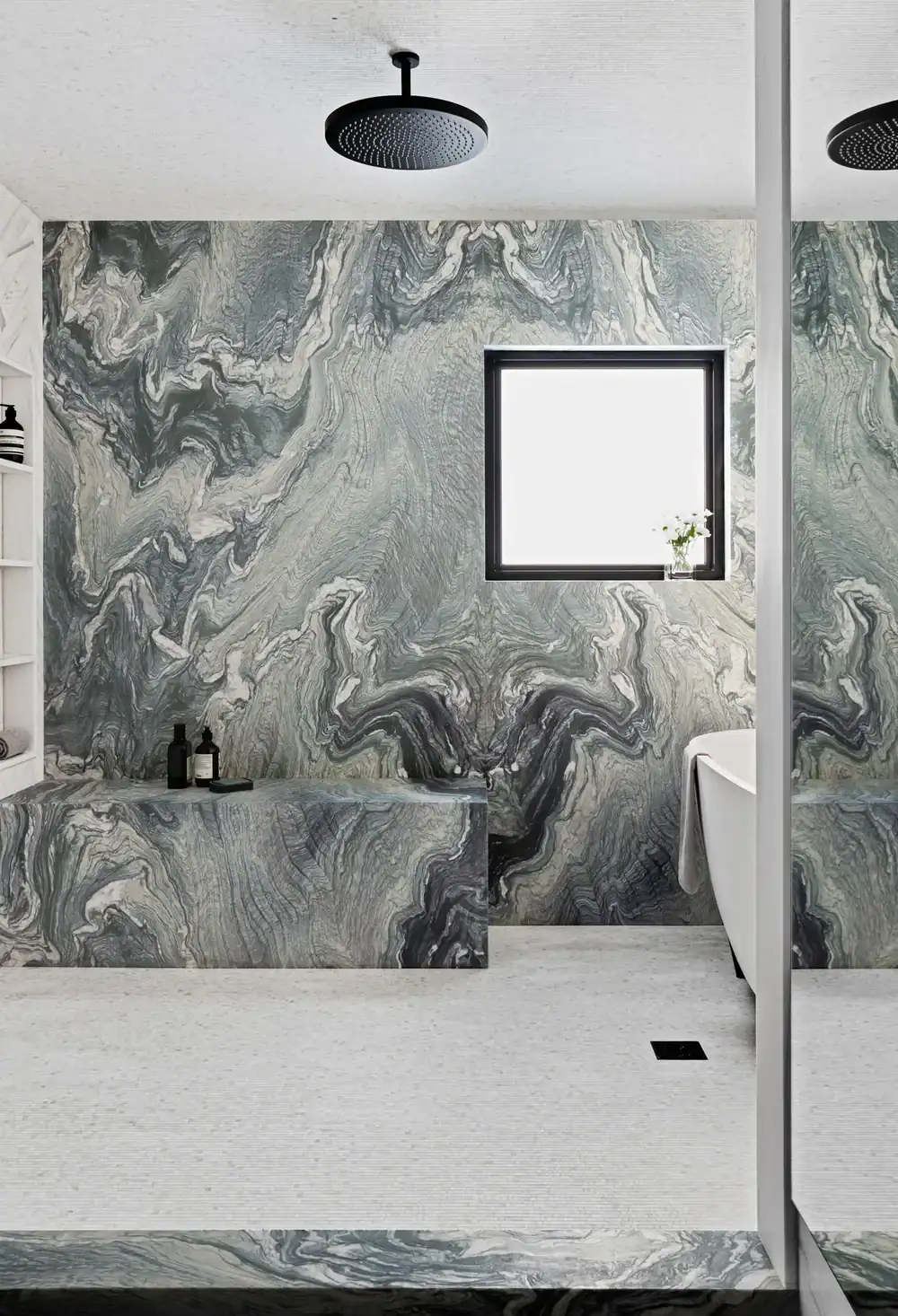 Modern bathroom with black rainfall showerhead and marble wall and tub.