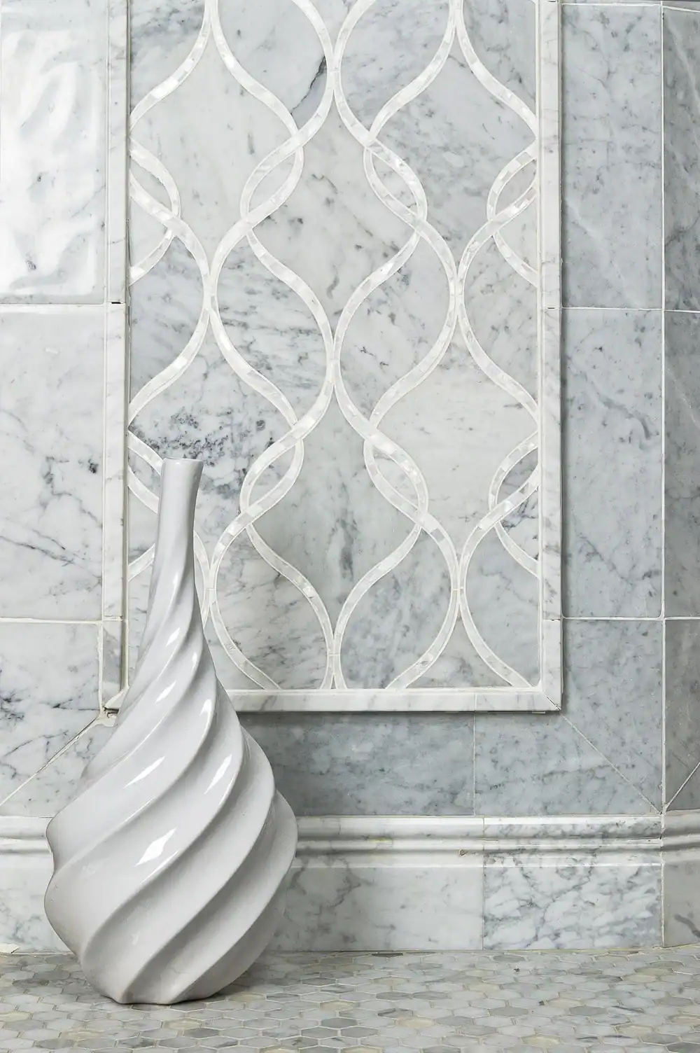 Elegant marble wall with decorative tile design and modern sculpture.