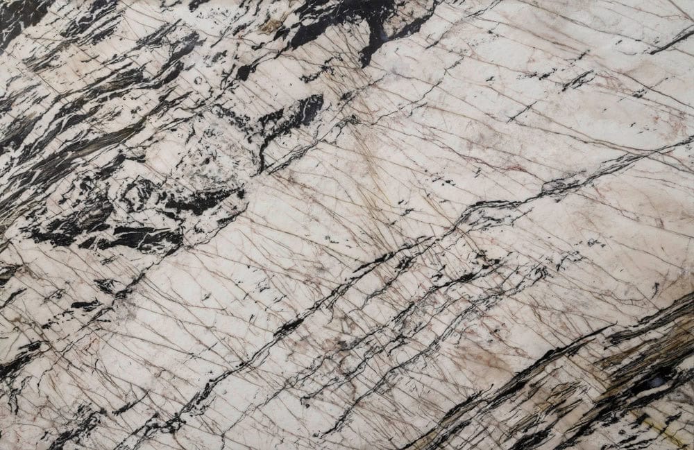 Close-up of beige and black veined marble surface for luxury interiors.