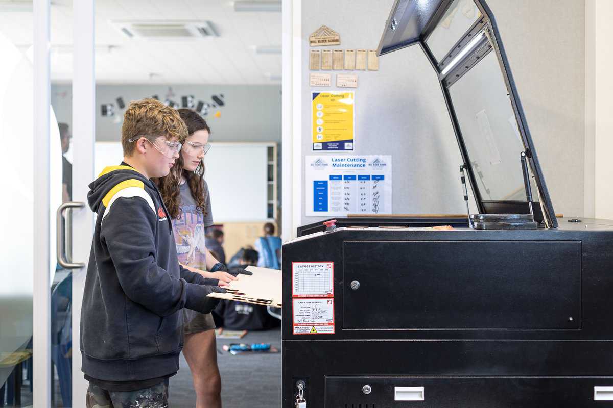 Children using laser cutter at Bell Block School tech lab, New Zealand.