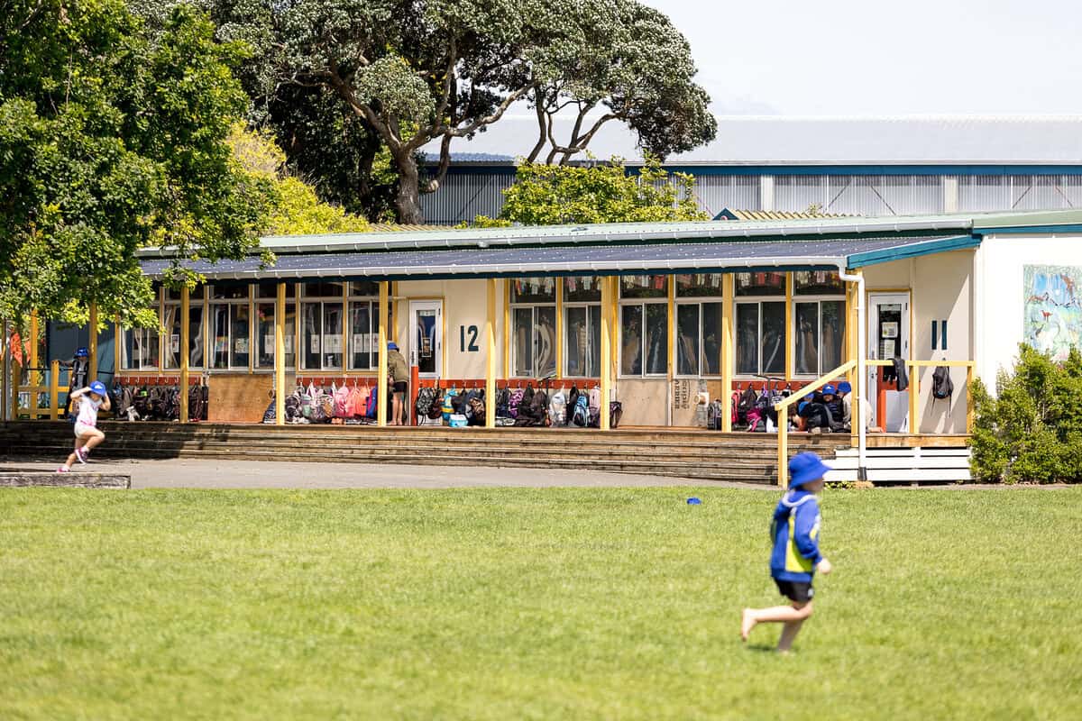 Bright preschool children playing outside at Bell Block School, New Zealand, during a sunny day.