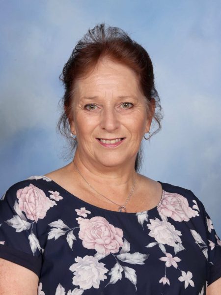Michelle Hight at Bell Block School, smiling in front of a blue sky background.