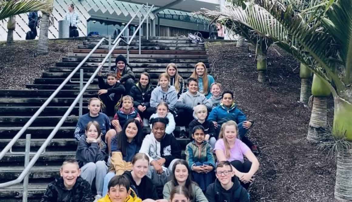 Kids group at Bell Block School, New Zealand, on the stairs outside the modern school building.